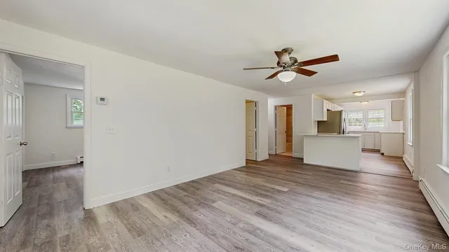 a view of a big room with wooden floor and a kitchen