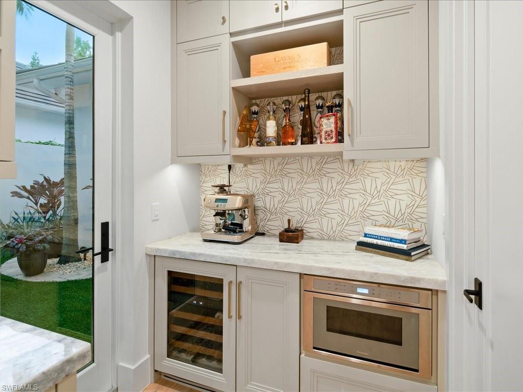 9185 Mercato Way Naples, FL 34108 - Photo 23 of 50 a kitchen with a stove and a microwave