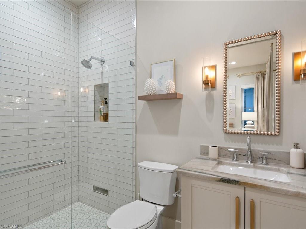 9185 Mercato Way Naples, FL 34108 - Photo 31 of 50 a bathroom with a granite countertop toilet a sink and a mirror