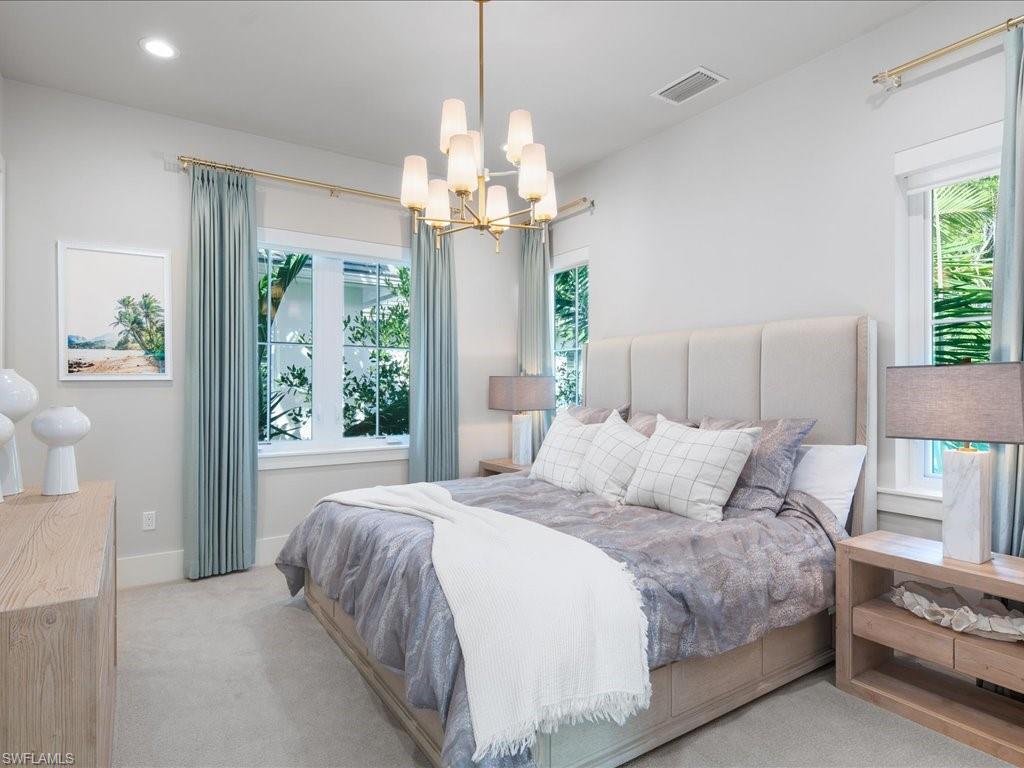 9185 Mercato Way Naples, FL 34108 - Photo 36 of 50 a bedroom with a bed and a chandelier