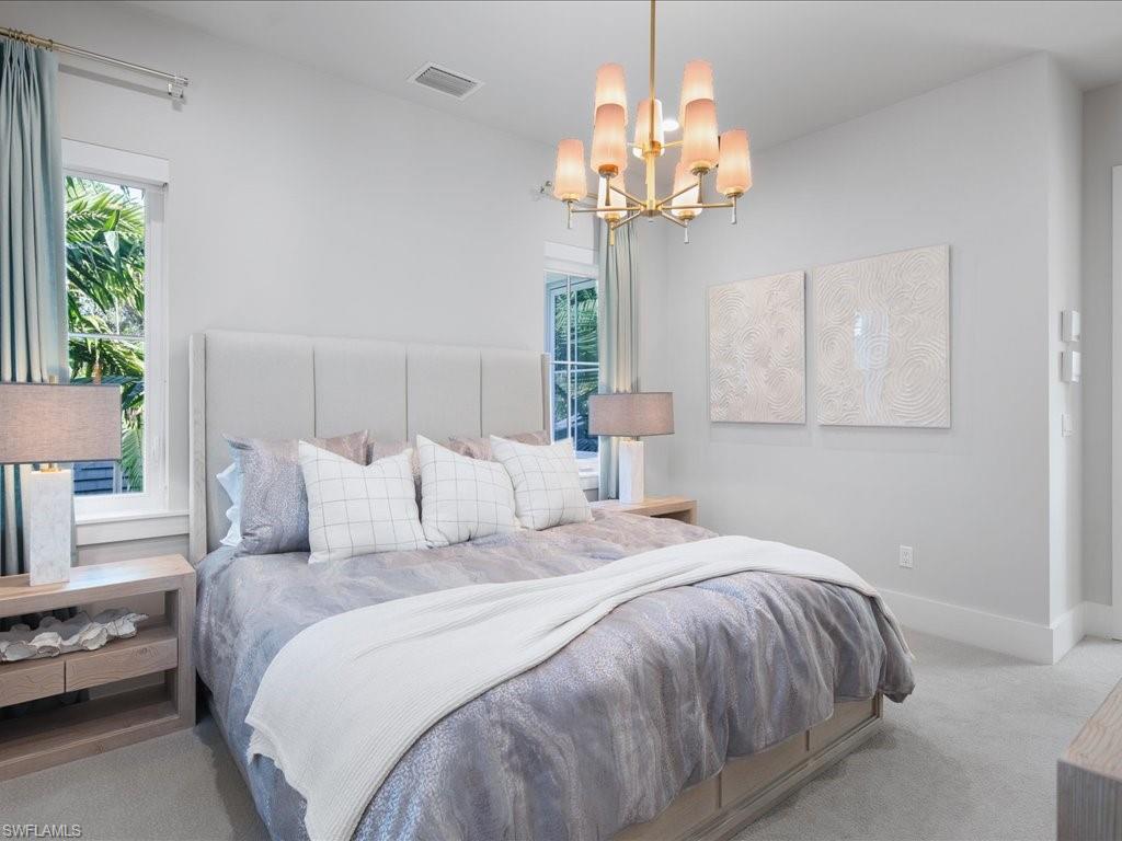 9185 Mercato Way Naples, FL 34108 - Photo 37 of 50 a bedroom with bed and a chandelier
