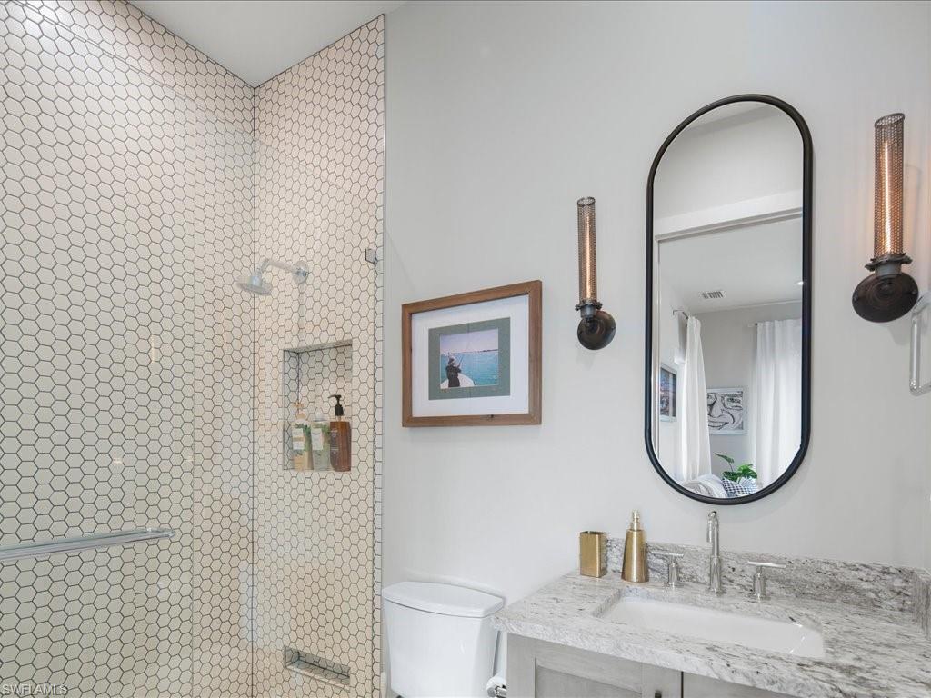 9185 Mercato Way Naples, FL 34108 - Photo 40 of 50 a bathroom with a toilet sink and mirror