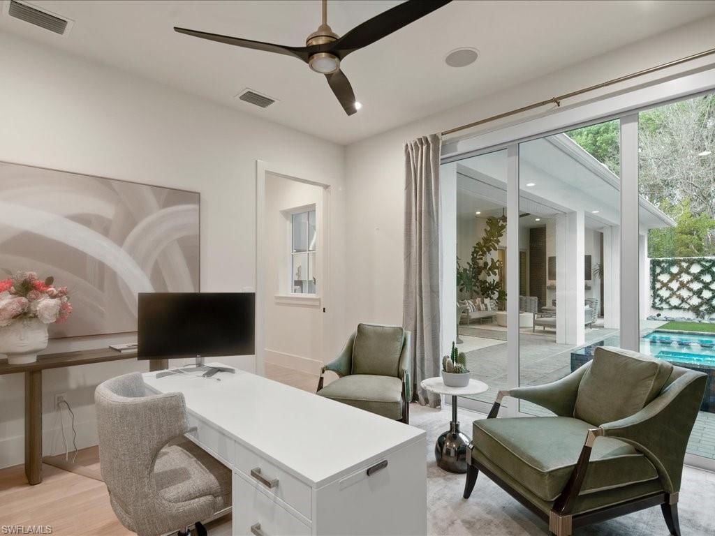 9185 Mercato Way Naples, FL 34108 - Photo 41 of 50 a living room with furniture a flat screen tv and a floor to ceiling window