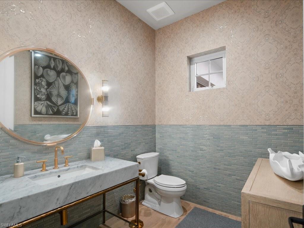 9185 Mercato Way Naples, FL 34108 - Photo 42 of 50 a bathroom with a toilet a sink and mirror