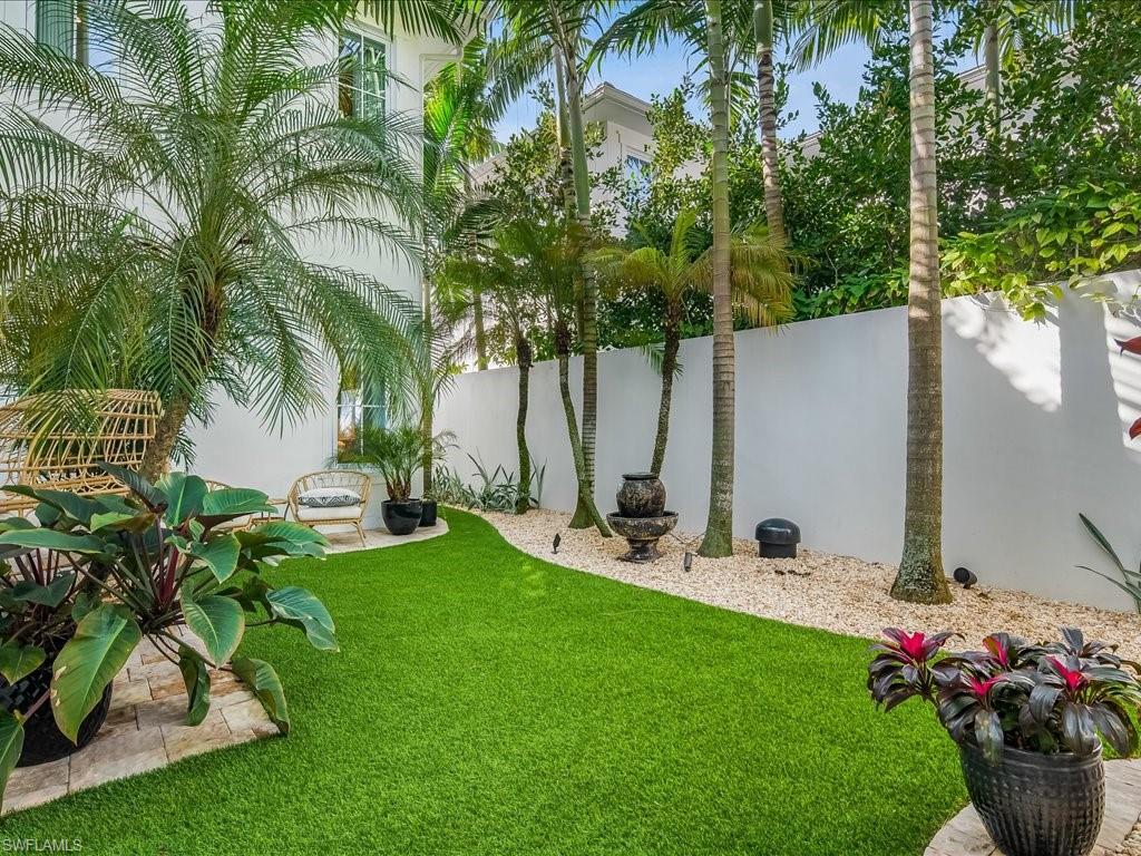 9185 Mercato Way Naples, FL 34108 - Photo 46 of 50 a view of a backyard with potted plants and a palm tree