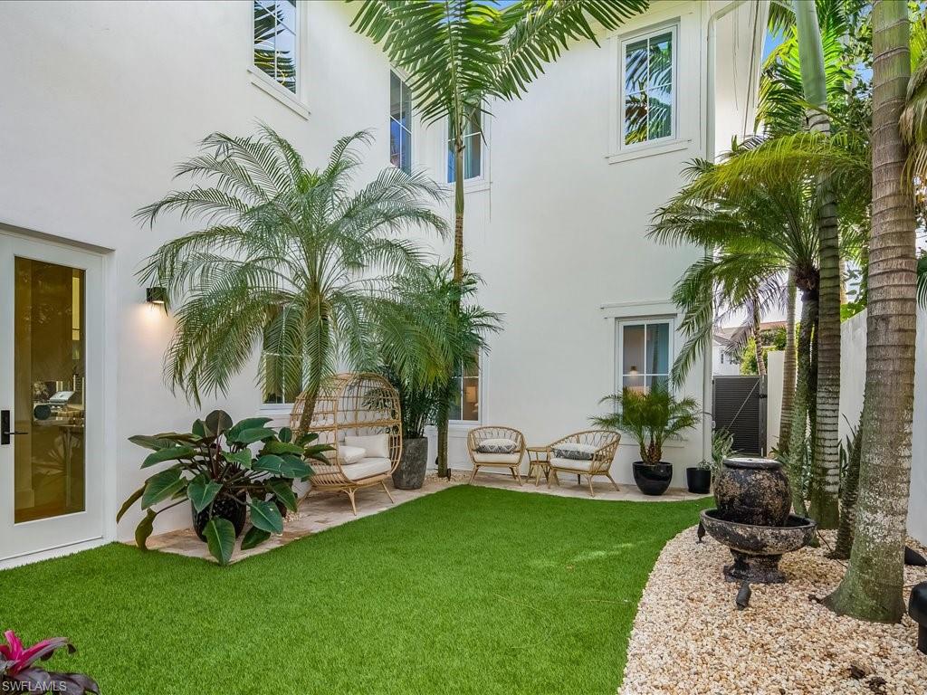 9185 Mercato Way Naples, FL 34108 - Photo 47 of 50 a view of a backyard with potted plants and palm trees