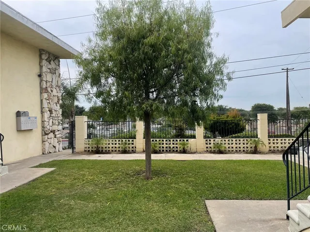 a view of a park that has a sign on a brick wall