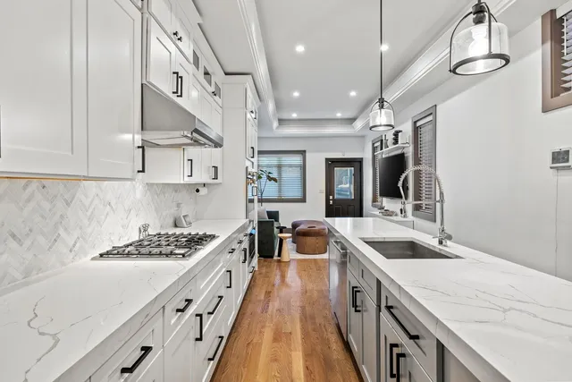 a kitchen with stainless steel appliances granite countertop a sink stove and refrigerator