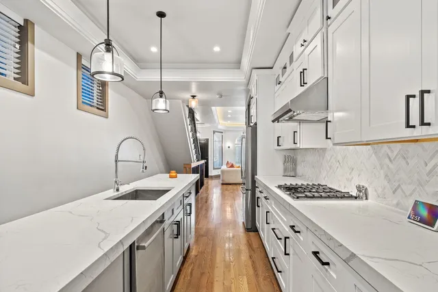 a kitchen with stainless steel appliances granite countertop a stove and white cabinets