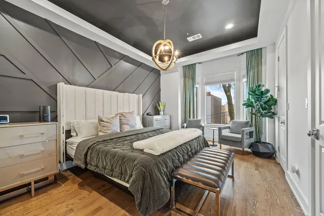 a bedroom with a bed and a chandelier