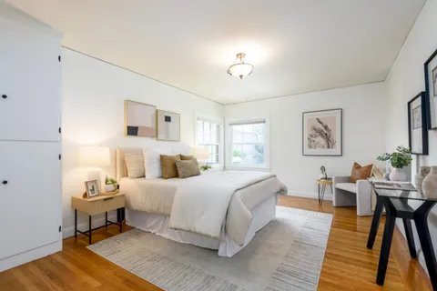 a bedroom with a bed and wooden floor