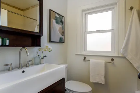 a bathroom with a sink mirror and toilet