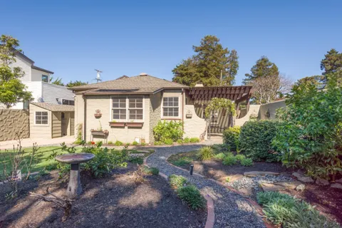 a front view of a house with a garden