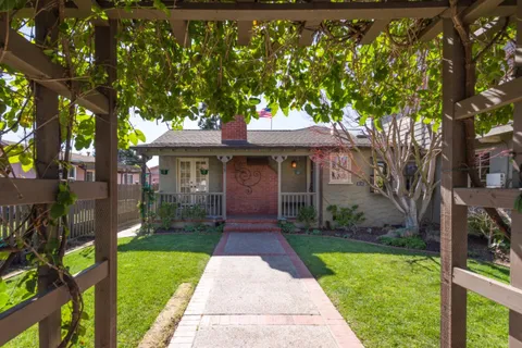 a front view of a house with a garden and trees