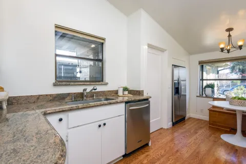 a kitchen with a sink cabinets and wooden floor