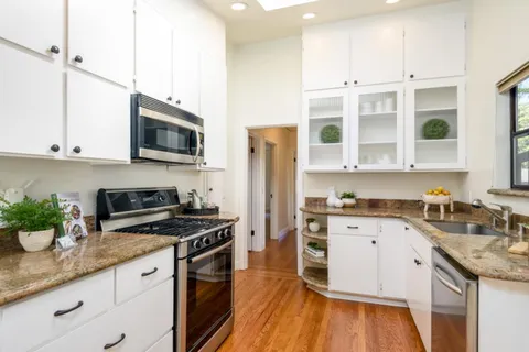 a kitchen with stainless steel appliances granite countertop a sink a stove a microwave and cabinets