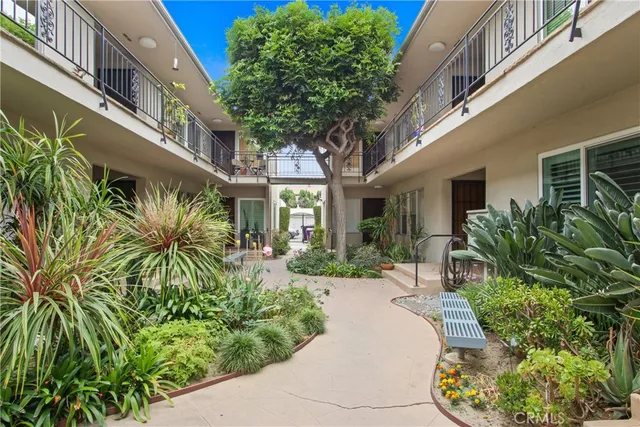 a view of a building with potted plants and a bench