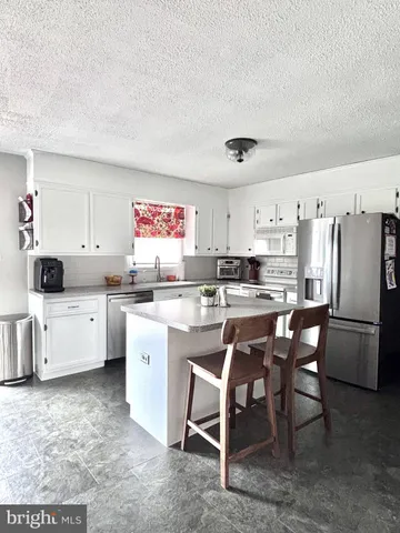 a kitchen with a refrigerator and white cabinets