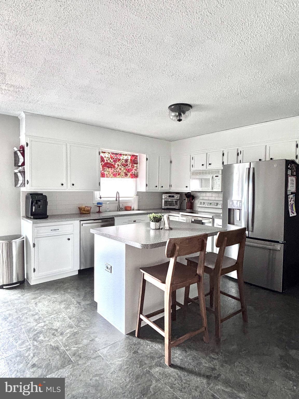 1119 East Meadow Road Manheim, PA 17545 - Photo 4 of 29 a kitchen with a refrigerator and white cabinets