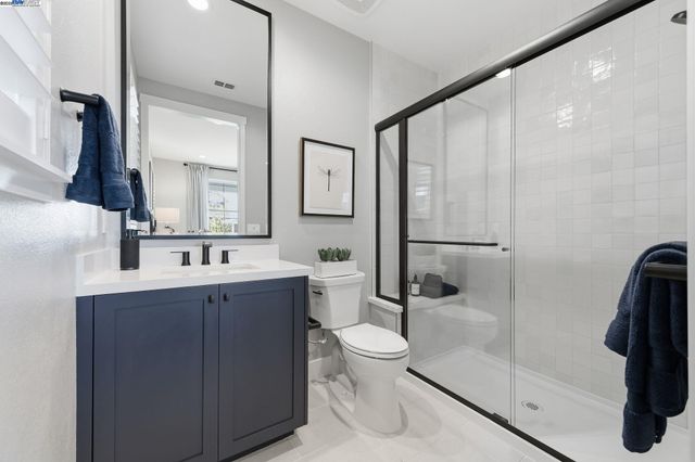 a bathroom with a bathtub shower sink mirror and toilet