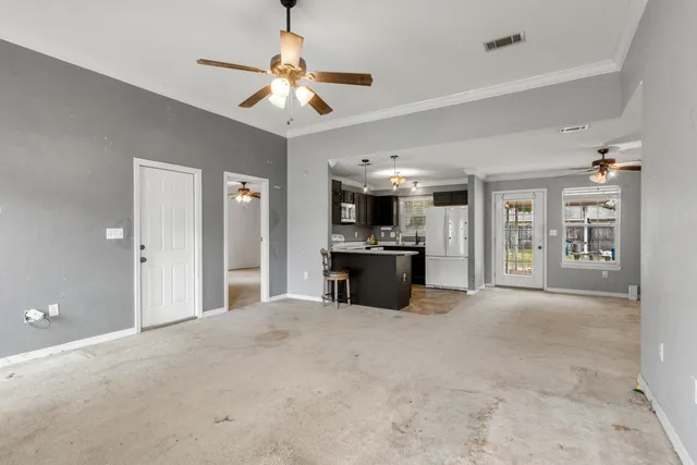 an empty room with windows and ceiling fan