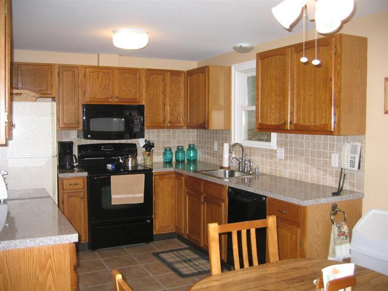 100 Ensign Road Centerville, MA 02632 - Photo 2 of 14 a kitchen with stainless steel appliances wooden cabinets a stove top oven a sink and dishwasher