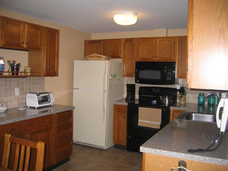 100 Ensign Road Centerville, MA 02632 - Photo 3 of 14 a kitchen with stainless steel appliances granite countertop a refrigerator a stove top oven a sink and dishwasher