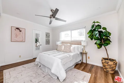 a bedroom with a large bed and a potted plant