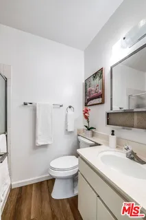 a bathroom with a sink mirror vanity and toilet