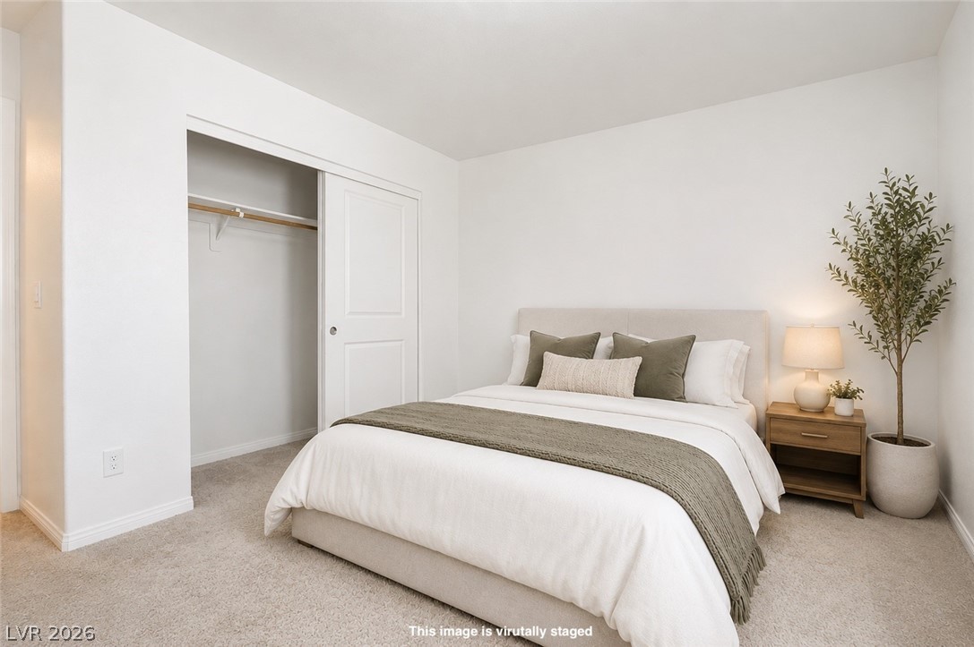12369 Golden Wreath Road, Unit 2 Las Vegas, NV 89183 - Photo 12 of 19 Well-lit and tranquil, this bedroom features soft carpeting and ample closet space.