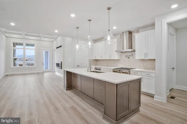 a large kitchen with stainless steel appliances kitchen island a large counter top and a wooden floors