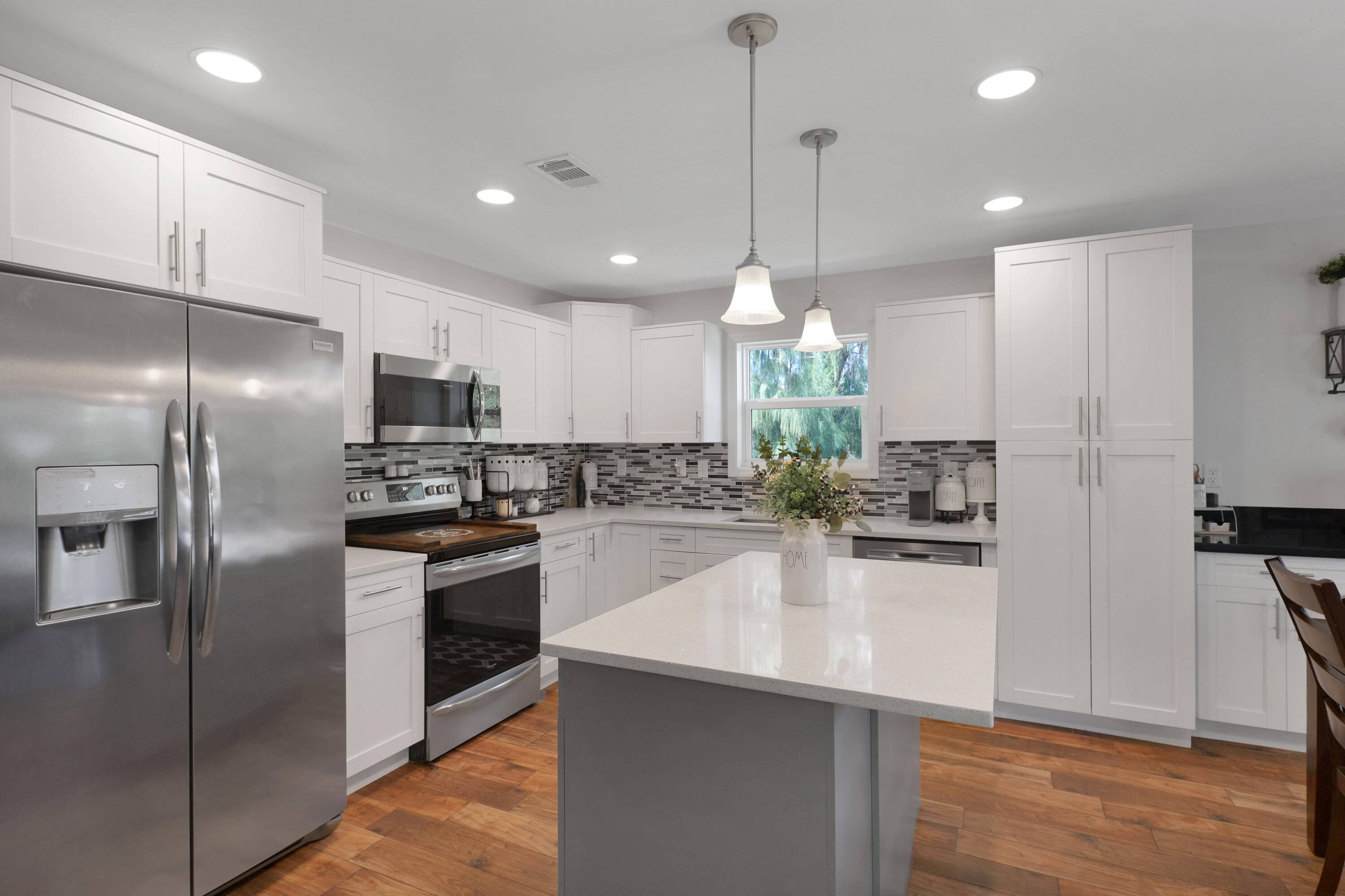27087 Angel Fish Road Summerland Key, FL 33042 - Photo 6 of 32 a kitchen with kitchen island a counter space stainless steel appliances and wooden floor
