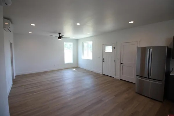 a view of a kitchen with a refrigerator and wooden floor