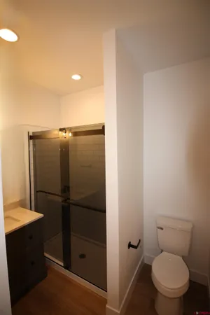 a bathroom with a granite countertop toilet and a sink