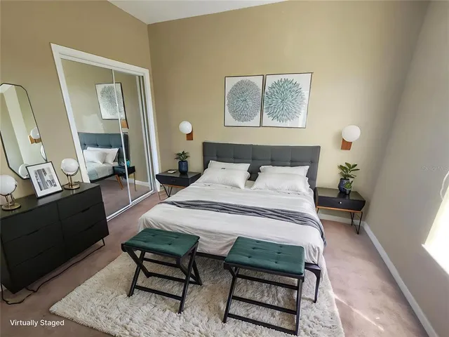 a bedroom with a bed a mirror on dresser and a window