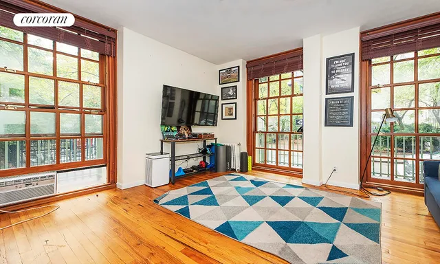 a bedroom with a bed and a flat tv screen next to a window