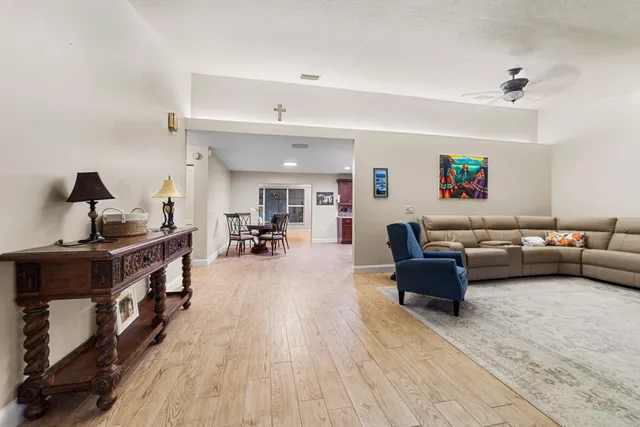 a view of a dining room and livingroom with furniture wooden floor a rug a potted plant