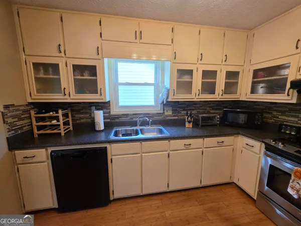 a kitchen with stainless steel appliances granite countertop a stove a sink and a microwave