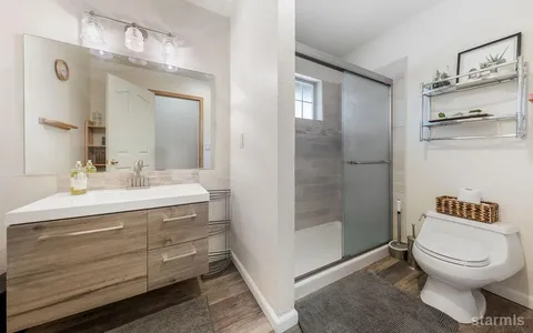 a bathroom with a toilet a sink and a mirror