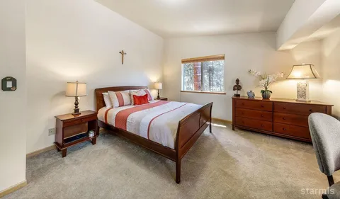 a bedroom with a bed dresser and a lamp