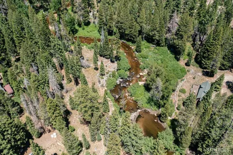 an aerial view of residential house with space and trees all around