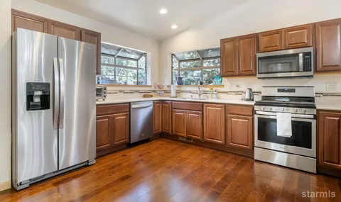 a kitchen with stainless steel appliances a stove sink microwave and refrigerator