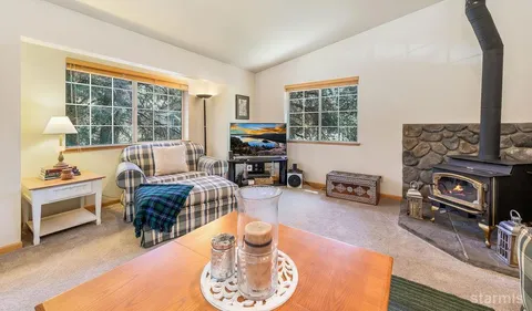 a living room with furniture a fireplace and large windows