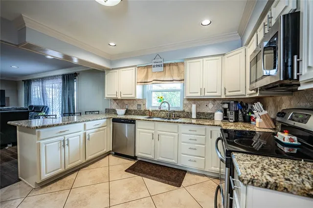 a kitchen with stainless steel appliances granite countertop a sink stove and microwave