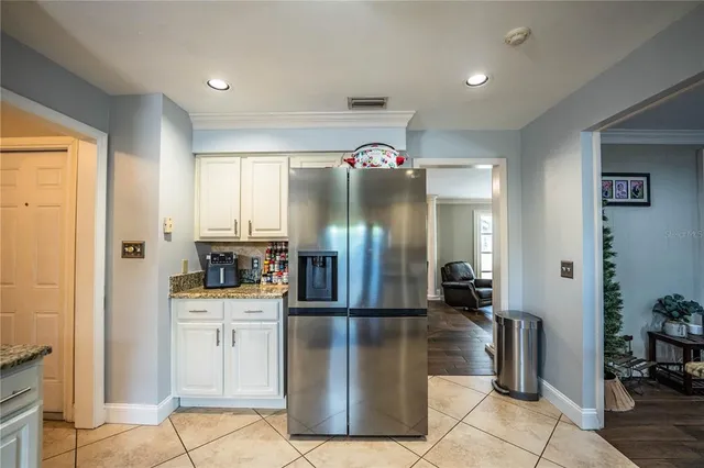 a kitchen with stainless steel appliances granite countertop a table chairs sink and cabinets