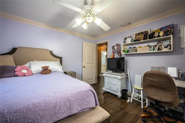 a bedroom with a bed lamp and a large window