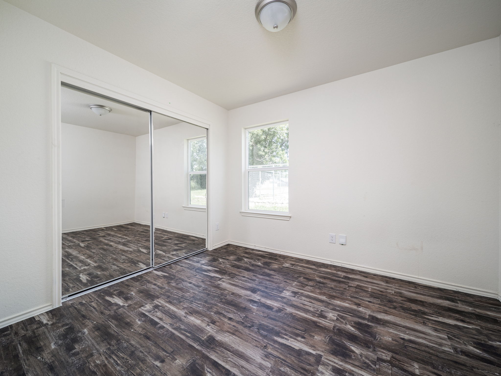 230 Debus Drive, Unit 108B Taylor, TX 76574 - Photo 11 of 16 Unfurnished bedroom featuring wood finished floors and a closet