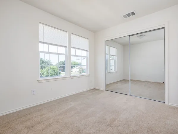 an empty room with windows and closet
