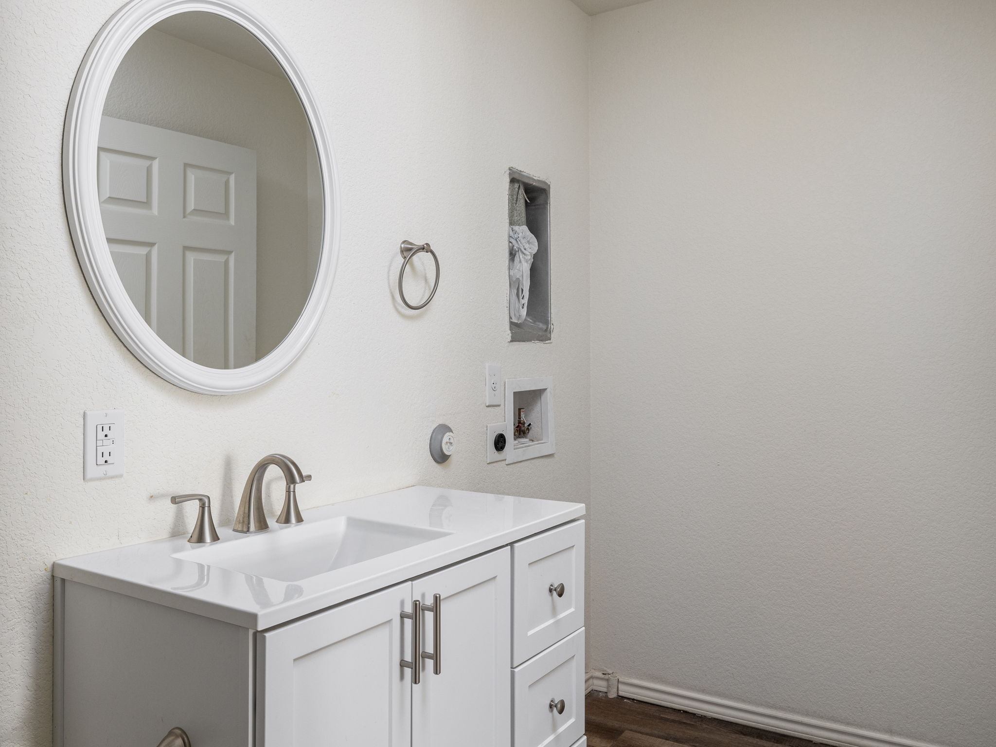230 Debus Drive, Unit 108B Taylor, TX 76574 - Photo 16 of 16 Bathroom featuring vanity, wood finished floors, and a textured wall