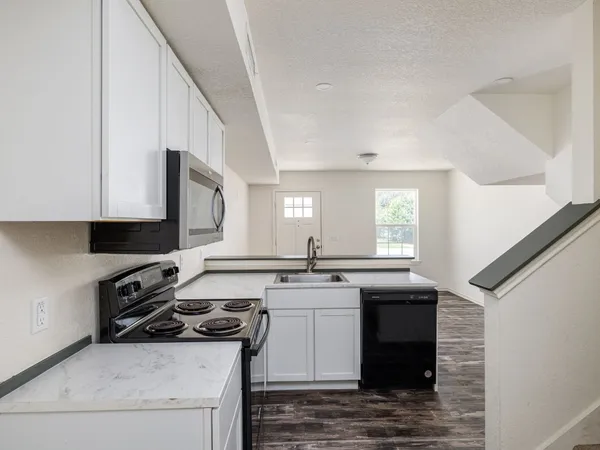 a kitchen with stainless steel appliances granite countertop a stove a sink and a microwave
